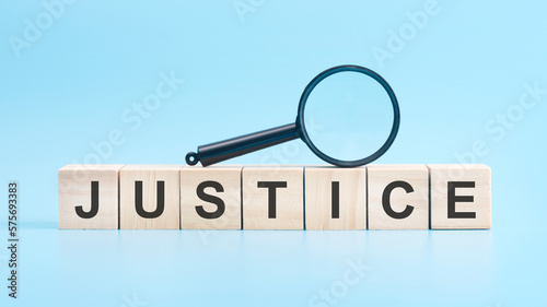wooden cubes with word JUSTICE on blue background.