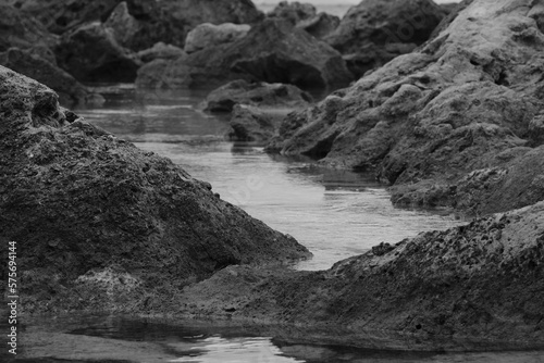 rocks washed by the waves of a Tuscan cliff in black and white