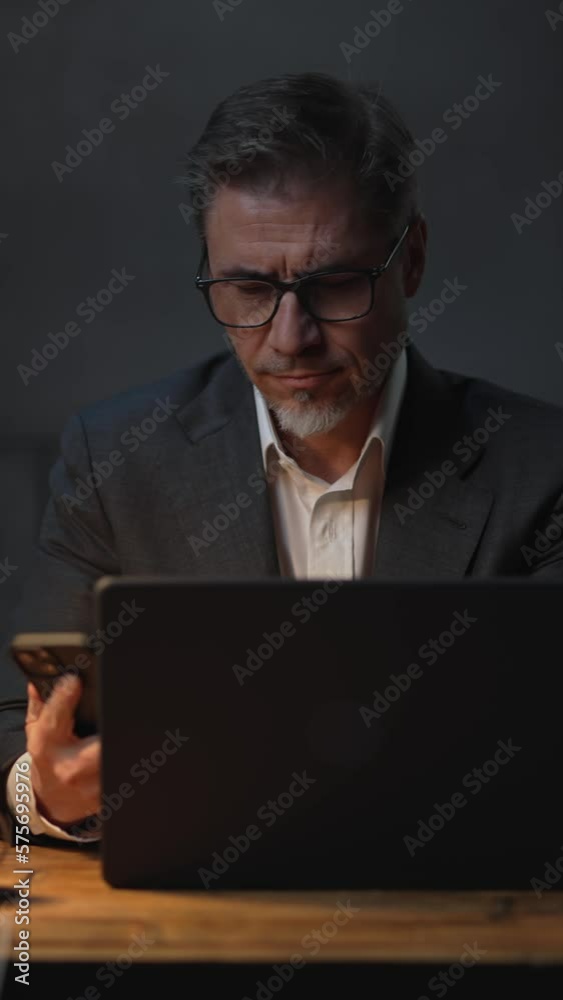 Businessman sitting at desk with laptop computer. Entrepreneur working late in office. Older, middle aged, mid adult, man in his 40s or 50s in jacket, business casual. Businessman sitting at desk with laptop computer. Entrepreneur working late in office. Older, middle aged, mid adult, man in his 40s or 50s in jacket, business casual.