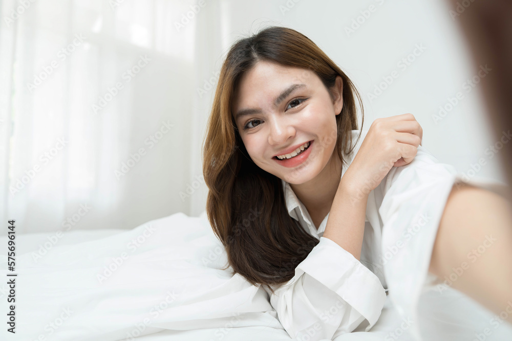 Beautiful young asian woman smiling sitting relax on the bed in the morning, girl using mobile smart phone talking enjoy, communication and social network concept. Beautiful young asian woman smiling sitting relax on the bed in the morning, girl using mobile smart phone talking enjoy, communication and social network concept.