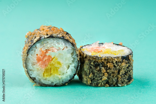 Sushi rolls tempura with salmon, cream cheese and sweet pepper on blue background.
