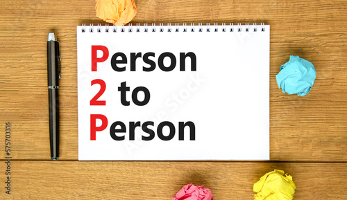 P2P person to person symbol. Concept words P2P person to person on white note on a beautiful wooden table wooden background. Pen. Business and P2P person to person concept. Copy space. © Dzmitry