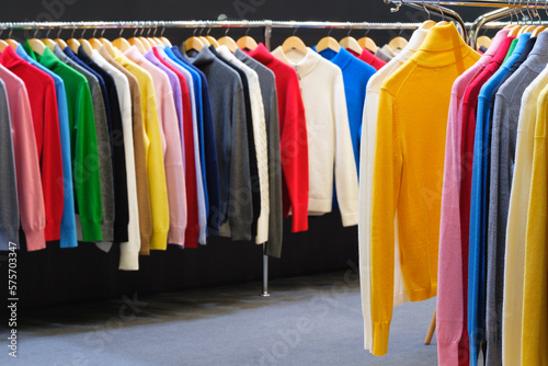 Fashion clothes on clothing rack bright colorful closet. Closeup of rainbow color choice of trendy female wear on hangers in store closet or spring cleaning concept. Summer home wardrobe. sweatshirts