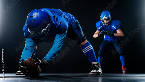 Two American football players are ready to start the game on a black background.  © Михаил Решетников