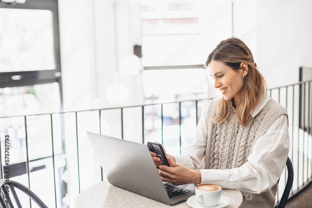 Happy woman using laptop and smartphone at cafe. Smiling woman using smart phone for business, online shopping, transfer money, financial, internet banking, make selfie in coffee shop cafe Happy woman using laptop and smartphone at cafe. Smiling woman using smart phone for business, online shopping, transfer money, financial, internet banking, make selfie in coffee shop cafe