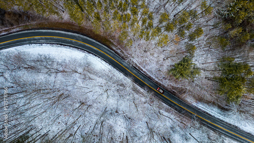 Drone photo of curved road through park in winter