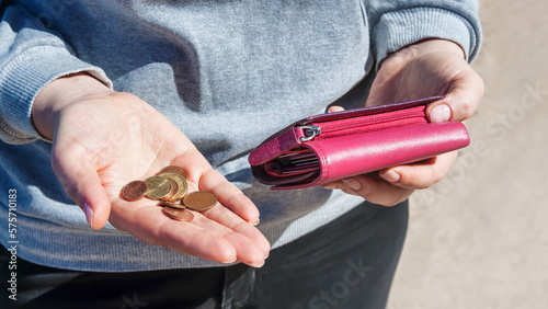 Pink purse and coins in female hands, selective focus.