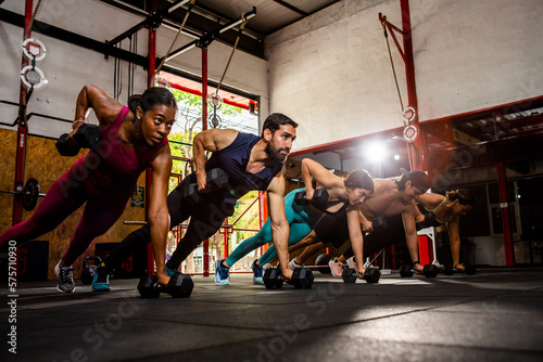 Group of people doing dumbbell push-ups