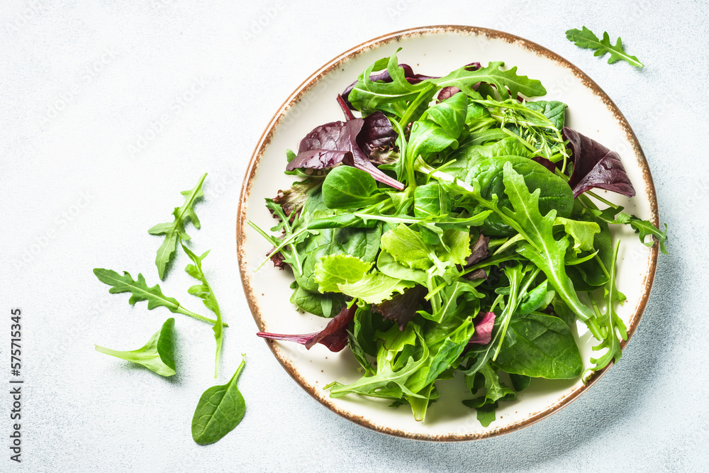 Green salad, fresh leaves in white plate. Top view. Green salad, fresh leaves in white plate. Top view.