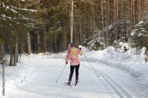 A woman goes cross-country skiing in winter through the forest on a special track. © Александр Поташев