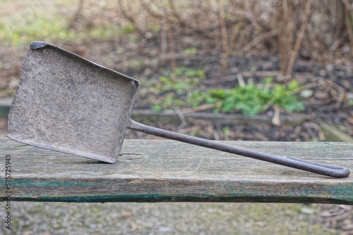 one old black iron scoop lies on a gray table in the street