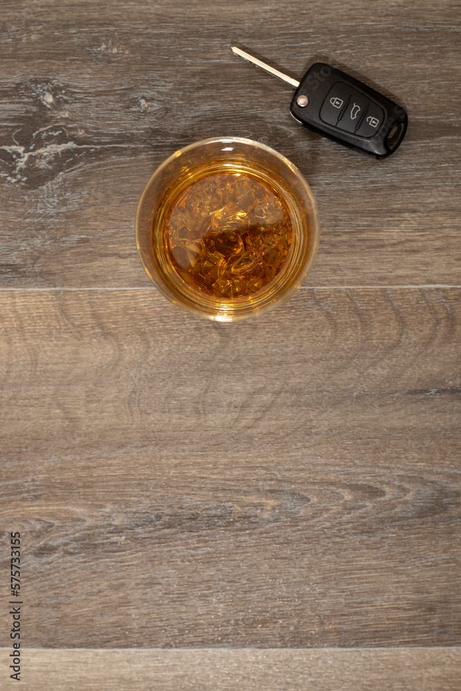 Drunk driving concept - car keys in the foreground with glass of whiskey Drunk driving concept - car keys in the foreground with glass of whiskey