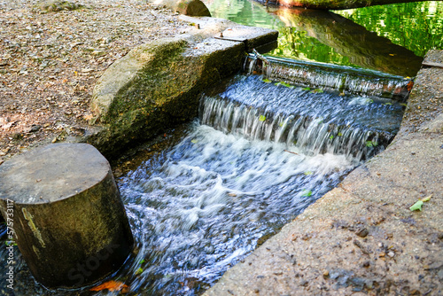 Fototapeta Naklejka Na Ścianę i Meble -  Water flowing over a overflow in a pond