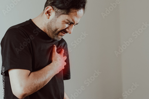 Photo of person clutching chest in pain. Concept of diseases, cardiac arrest, heart pain, health.
