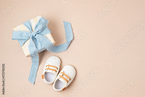 Baby shower, gender reveal, birthday party background with gift box and baby shoes. Top view, flatlay, copy space