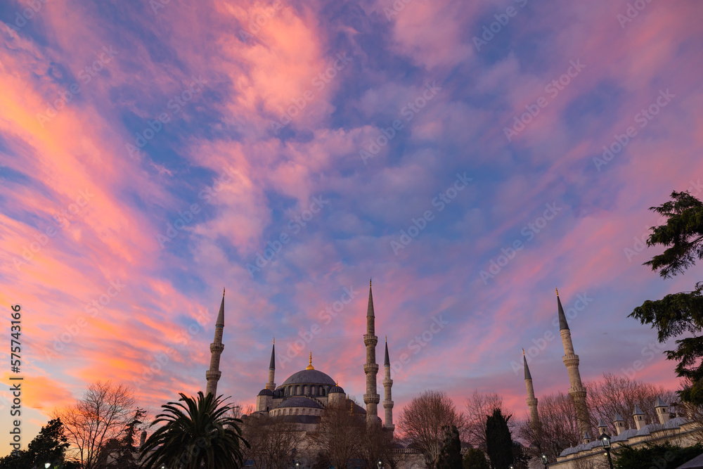 Blue Mosque aka Sultanahmet Mosque at sunrise with pink and orange clouds