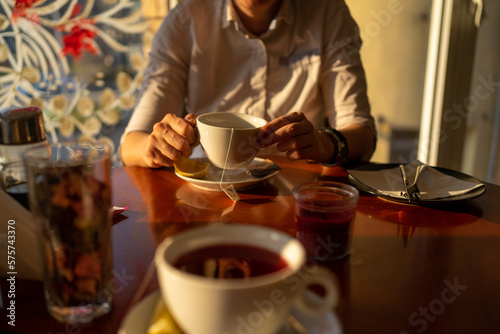 Middle age woman drinking tea at the restaurant  close up photo. 