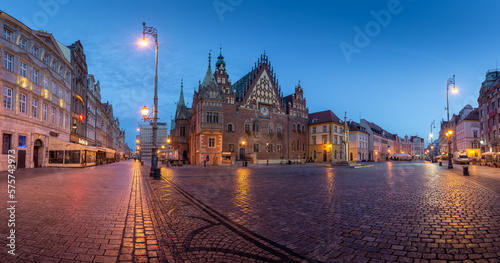 Panorama of the main square of Wroclaw with the old city hall and nearby buildings and street lights during evening