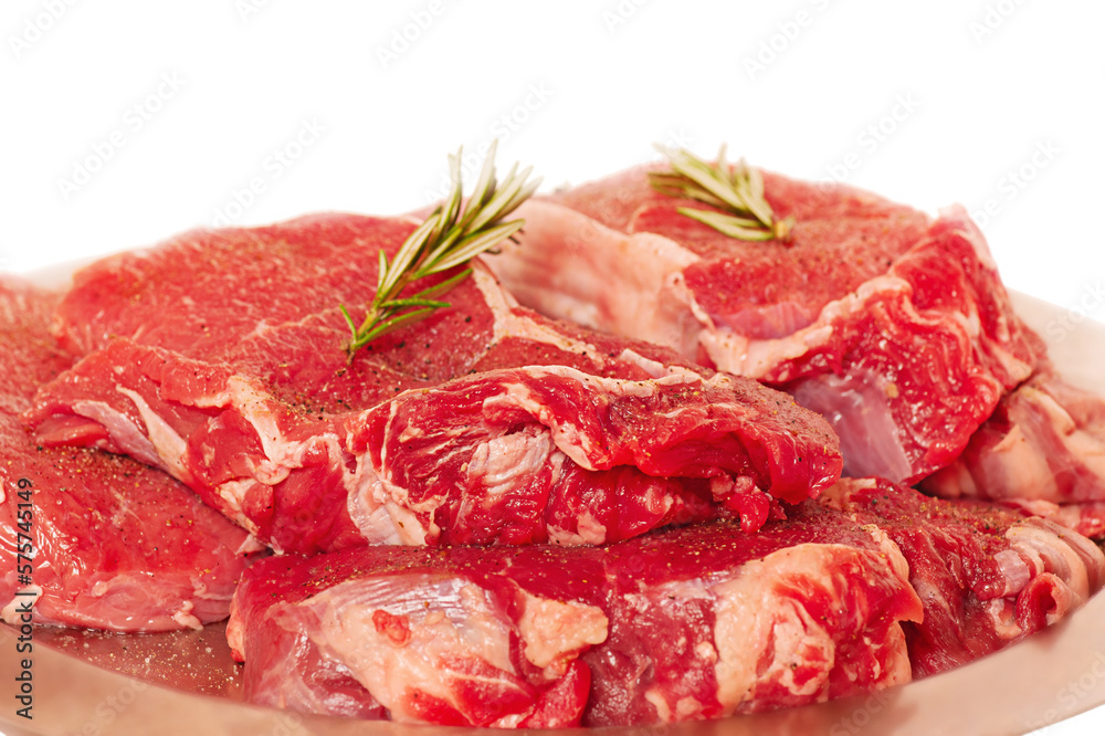 Beef steaks on a metal plate. Meat for cooking with rosemary isolated on white.
