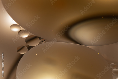 Circles of oil in water with a brown background abstract macro