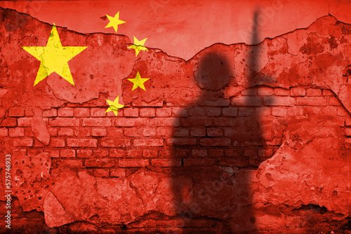 Flag of China painted on a concrete wall with soldier shadow photo