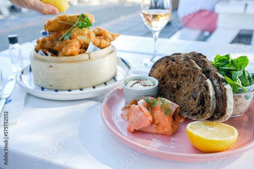 Beer-battered flathead, a glass of rose wine and a plate of smoked trout, pate and dark rye sourdough at a cafe in Palm Beach, Sydney — New South Wales, Australia