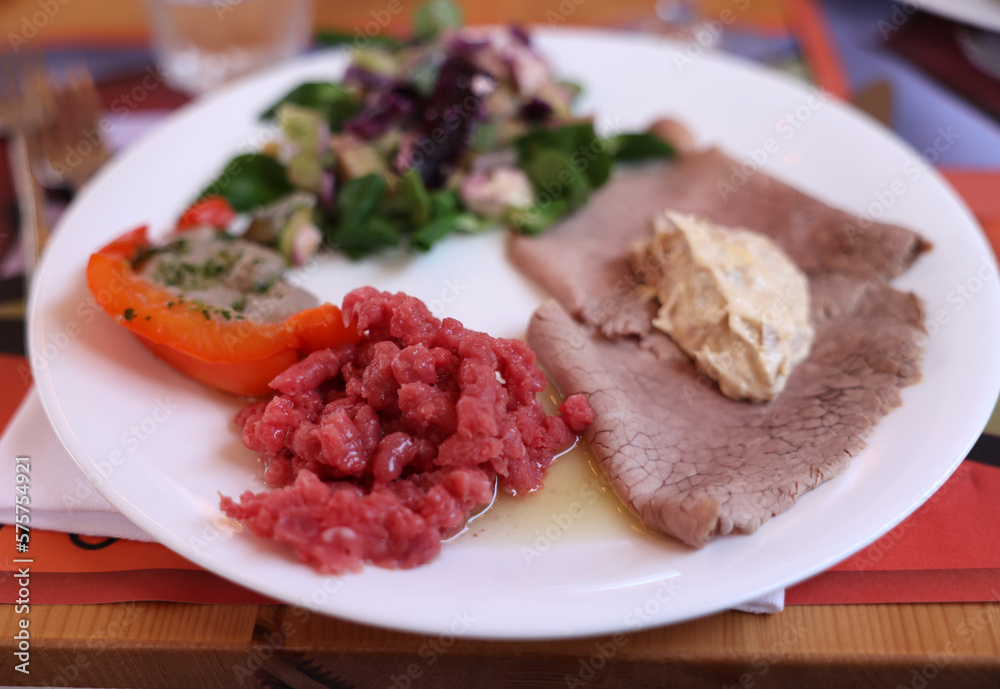 A delicious starter from Piedmont. Steak tartare, carpaccio, stuffed peppers, and salad A delicious starter from Piedmont. Steak tartare, carpaccio, stuffed peppers, and salad