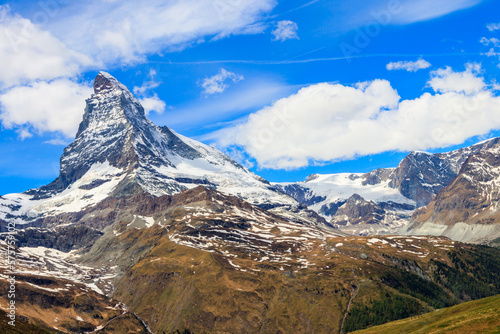 Scenic view on snowy Matterhorn mountain peak in sunny day with blue sky in Switzerland. Beautiful nature background of Swiss Alps covered with snow. Famous travel destination