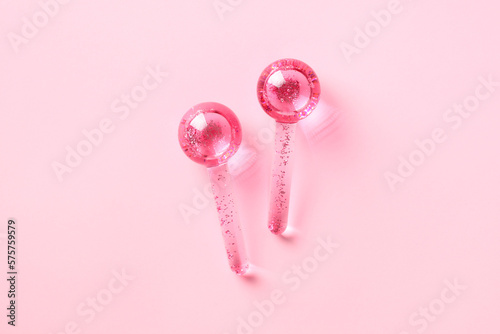 Ice globes for facials, face massager tool on pink background. photo
