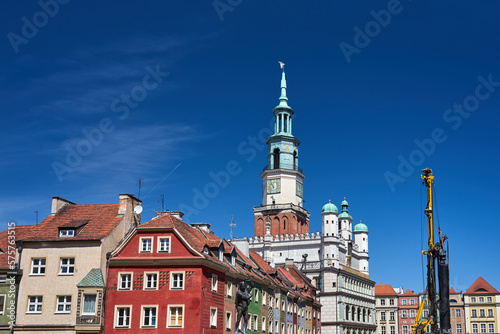 Historic tenement houses, historic town hall tower and construction machine on the market square in Poznan