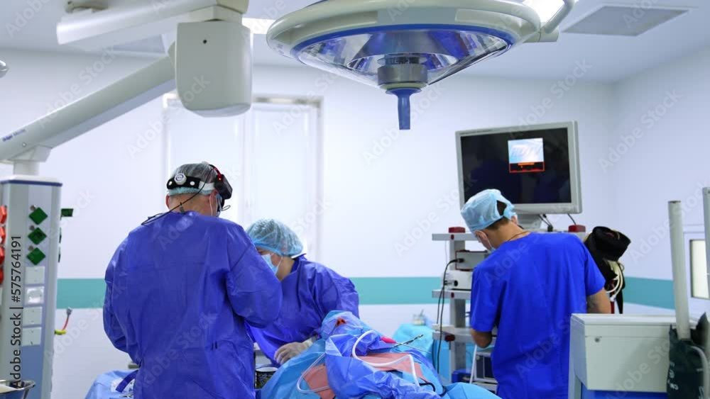Surgeon standing his back to camera picking instrument for operation. Getting ready for rhinoplasty in hospital. Surgeon standing his back to camera picking instrument for operation. Getting ready for rhinoplasty in hospital.