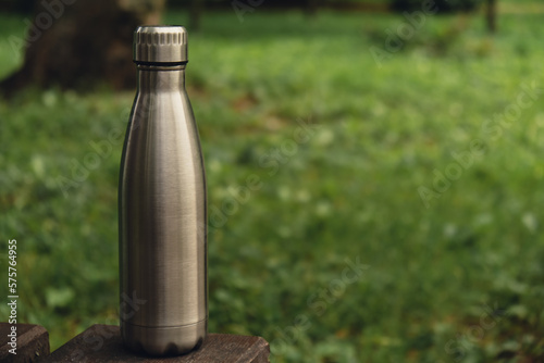 Water bottle. Reusable steel thermo water bottle on green grass. Sustainable lifestyle. Plastic free zero waste free living. Go green Environment protection. Health-conscious. Steel thermo water