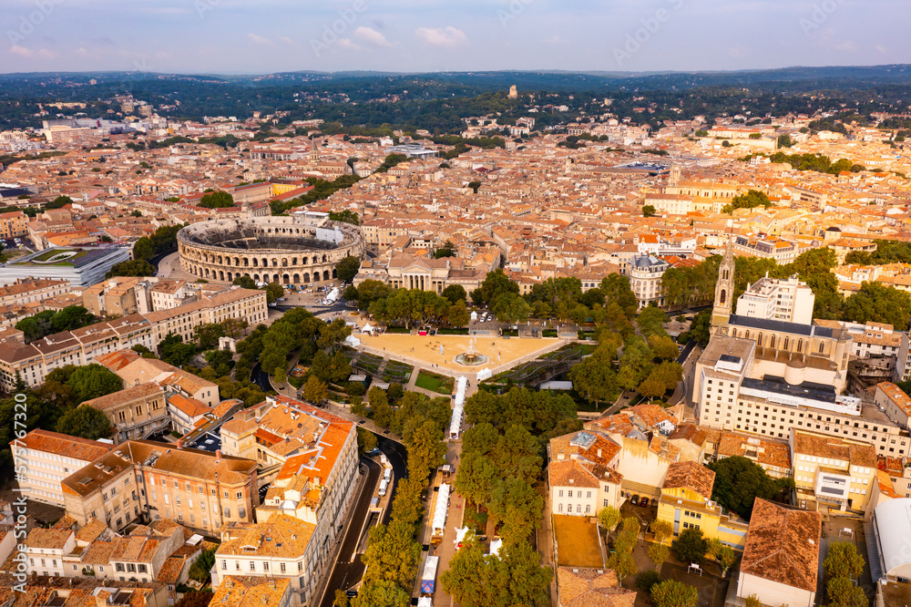 Aerial view of Roman amphitheatre on background with cityscape of Nimes. France