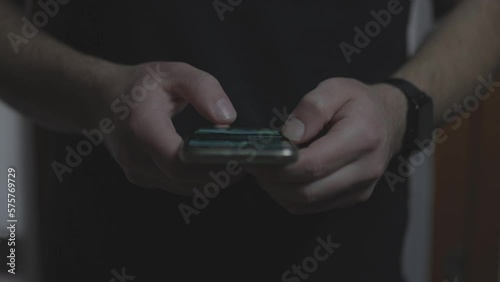 Doom scrolling. Hands of bored man scrolls page app on mobile phone. Browsing internet or social network. Compulsive scrolling concept. Front view