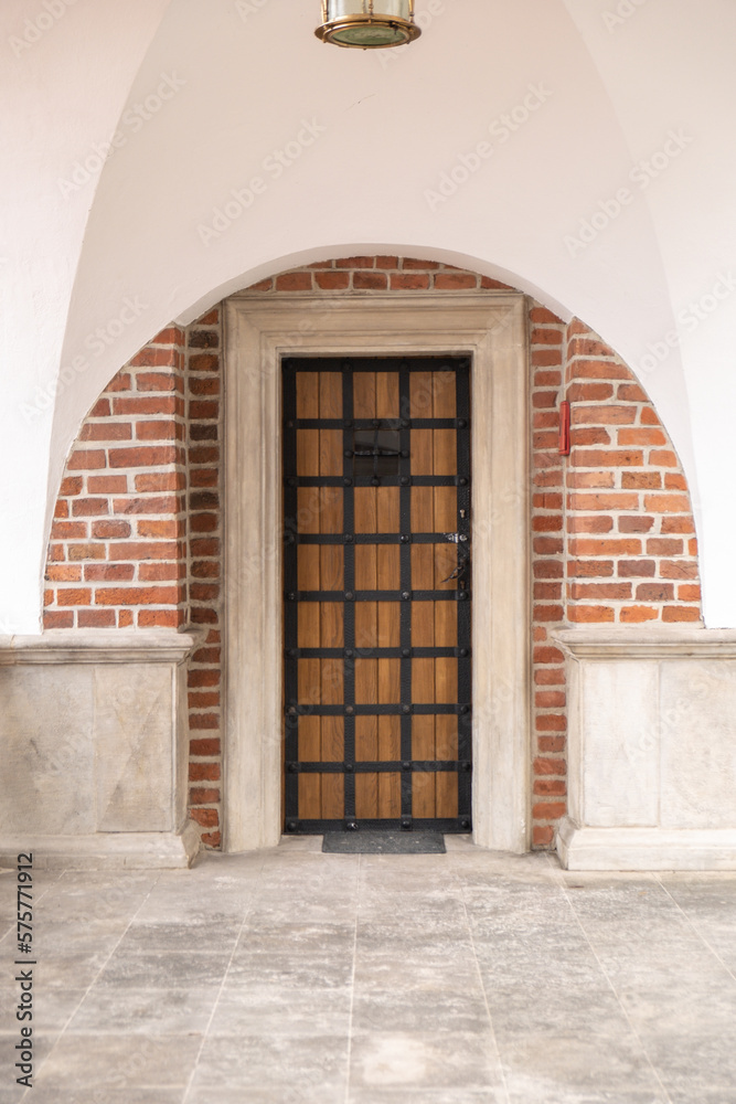 Old wooden brown house door. Gorgeous wooden door in the streets Krakow Poland. antique wooden front door with wrought-iron hinges and hook Old wooden brown house door. Gorgeous wooden door in the streets Krakow Poland. antique wooden front door with wrought-iron hinges and hook