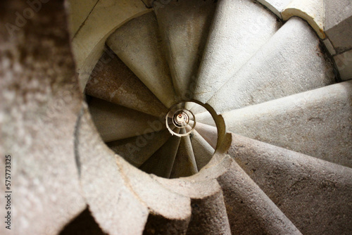 Fotobehang spiral staircase in light stone giving the impression of a vertigo tunnel