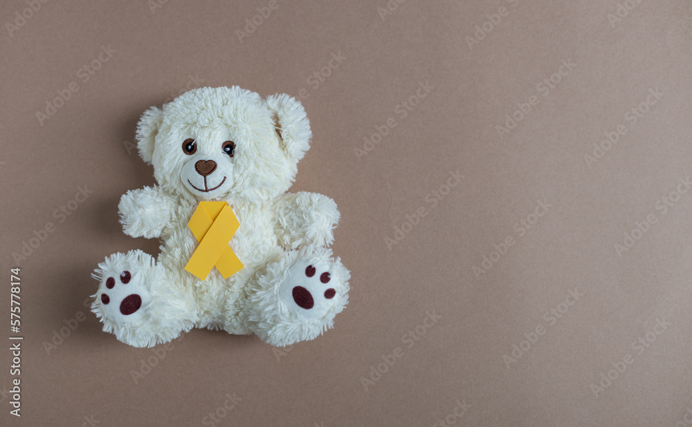 Toy bear with a yellow ribbon on a nude background. Toy bear with a yellow ribbon on a nude background.