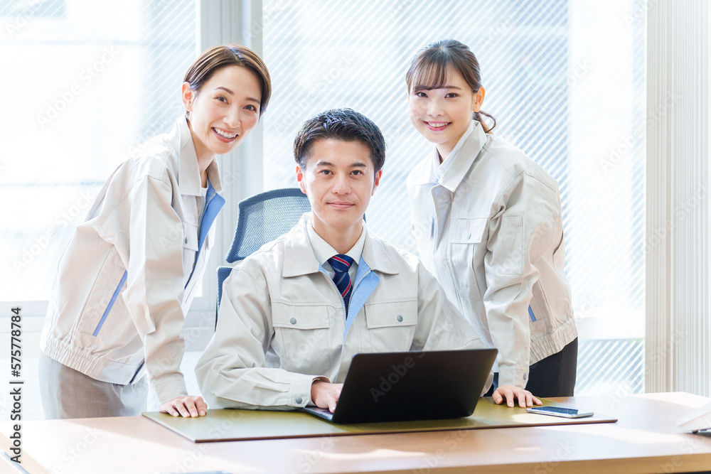 オフィスでパソコンを使う作業服を着た人々 オフィスでパソコンを使う作業服を着た人々
