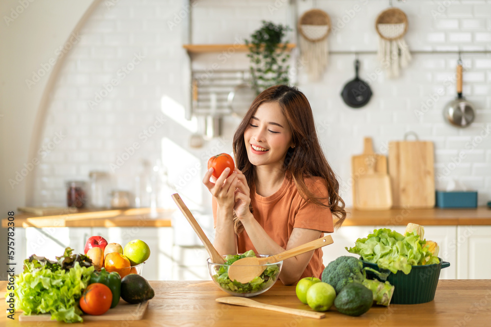Portrait of beauty body slim healthy asian woman having fun cooking and preparing cooking vegan food healthy eat with fresh vegetable salad in kitchen at home.Diet concept.Fitness and healthy food