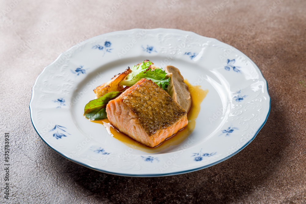 Salmon steak on the grill on plate on brown table Salmon steak on the grill on plate on brown table