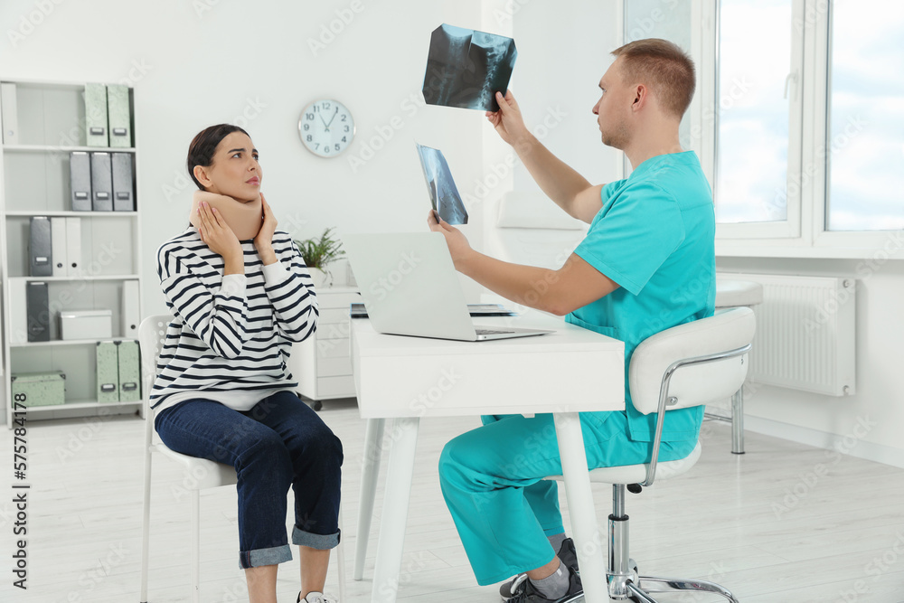 Doctor with neck MRI images consulting patient in clinic Doctor with neck MRI images consulting patient in clinic
