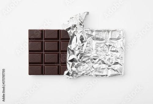 Tasty chocolate bar on white background, top view photo