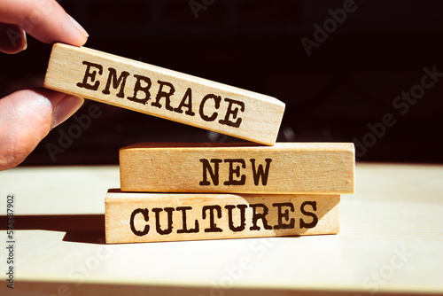 Wooden blocks with words 'Embrace New Cultures'.
