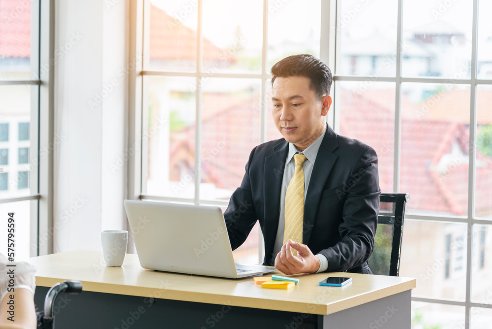 Asian Businessman using laptop at office desk. Man hands typing computer keyboard reading financial graph chart Planning analyzing marketing data. happy Asian business men people working office firm Asian Businessman using laptop at office desk. Man hands typing computer keyboard reading financial graph chart Planning analyzing marketing data. happy Asian business men people working office firm