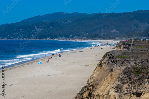 2022-08-13 HALF MOON BAY SANDY BEACH WITH ROLLING HILLS IN THE BACKGROUND AND A ROCKY OUTCROP © Michael J Magee