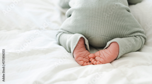 Cute feet of newborn baby sleeping on stomach on white blanket.Close-up shot .Copy space for text. photo