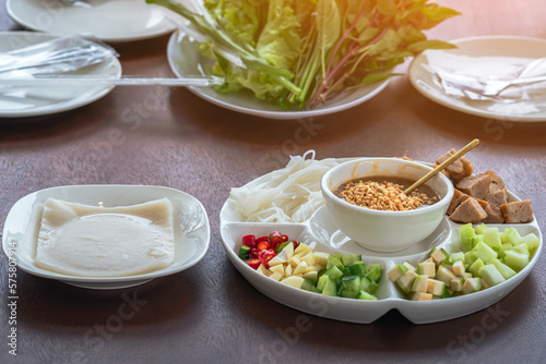 Close up to dipping sauce for Vietnamese Meatball Wraps (Nam-Neung), Pork Sausage wraps with fresh vegetables in rice paper, generous platter eat with sweet sauce. Vietnamese Pork Sausage and salad.