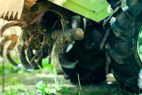 Rototiller of a walk-behind tractor close-up. Agricultural machinery for processing and care of the soil. Small tractor for plowing the garden soil photo