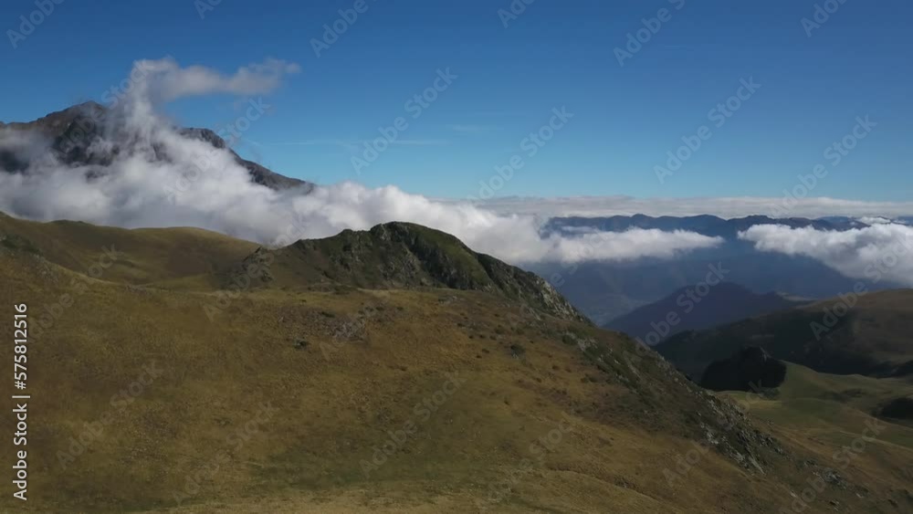 Mountains shrouded in clouds on sunny summer day, Col du Portet in France. Aerial forward and blue sky for copy space Mountains shrouded in clouds on sunny summer day, Col du Portet in France. Aerial forward and blue sky for copy space