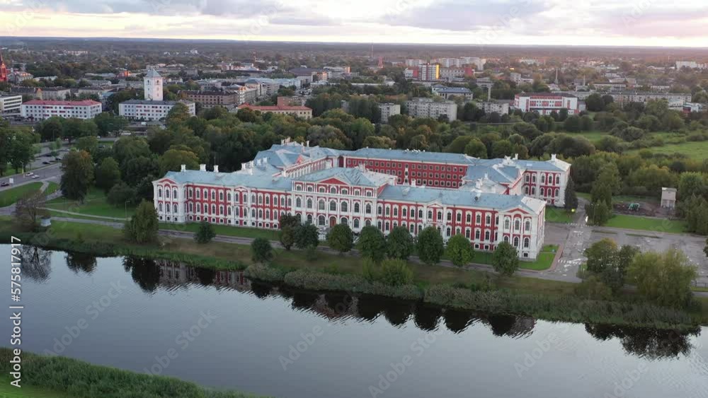 A drone glides over an 18th-century palace, adjacent to a river and a bridge, as the city glows in the warmth of a stunning sunset A drone glides over an 18th-century palace, adjacent to a river and a bridge, as the city glows in the warmth of a stunning sunset